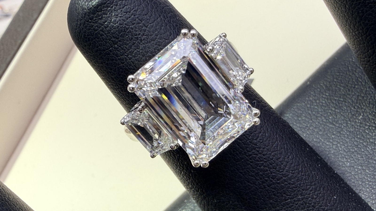 Emerald-cut three-stone engagement ring with trapezoid side stones, photographed by Miss Diggs