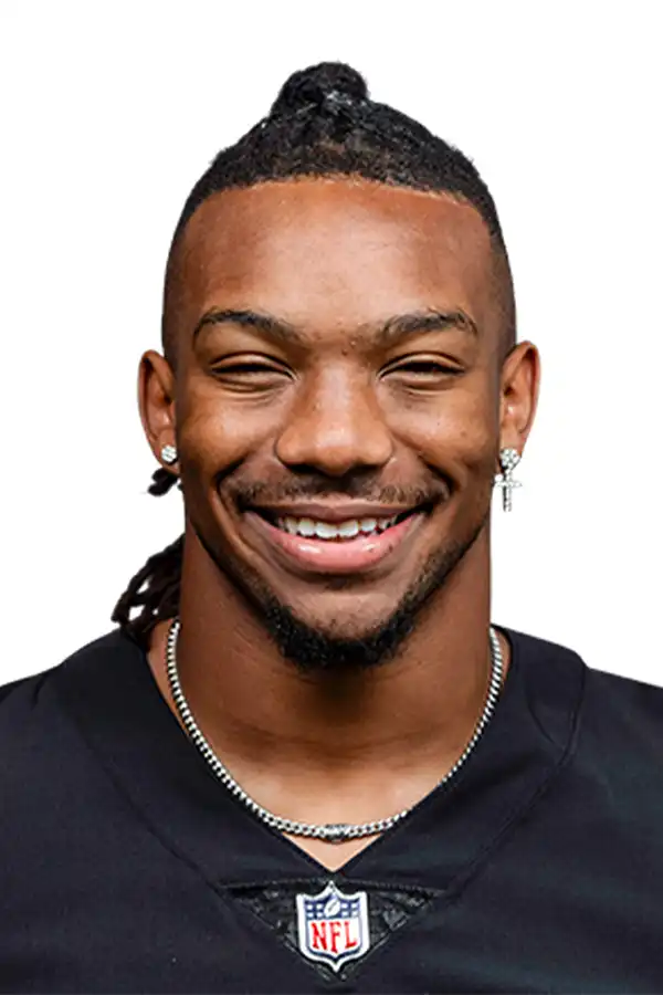 Portrait of Bijan Robinson smiling in an Atlanta Falcons jersey, wearing earrings and a chain