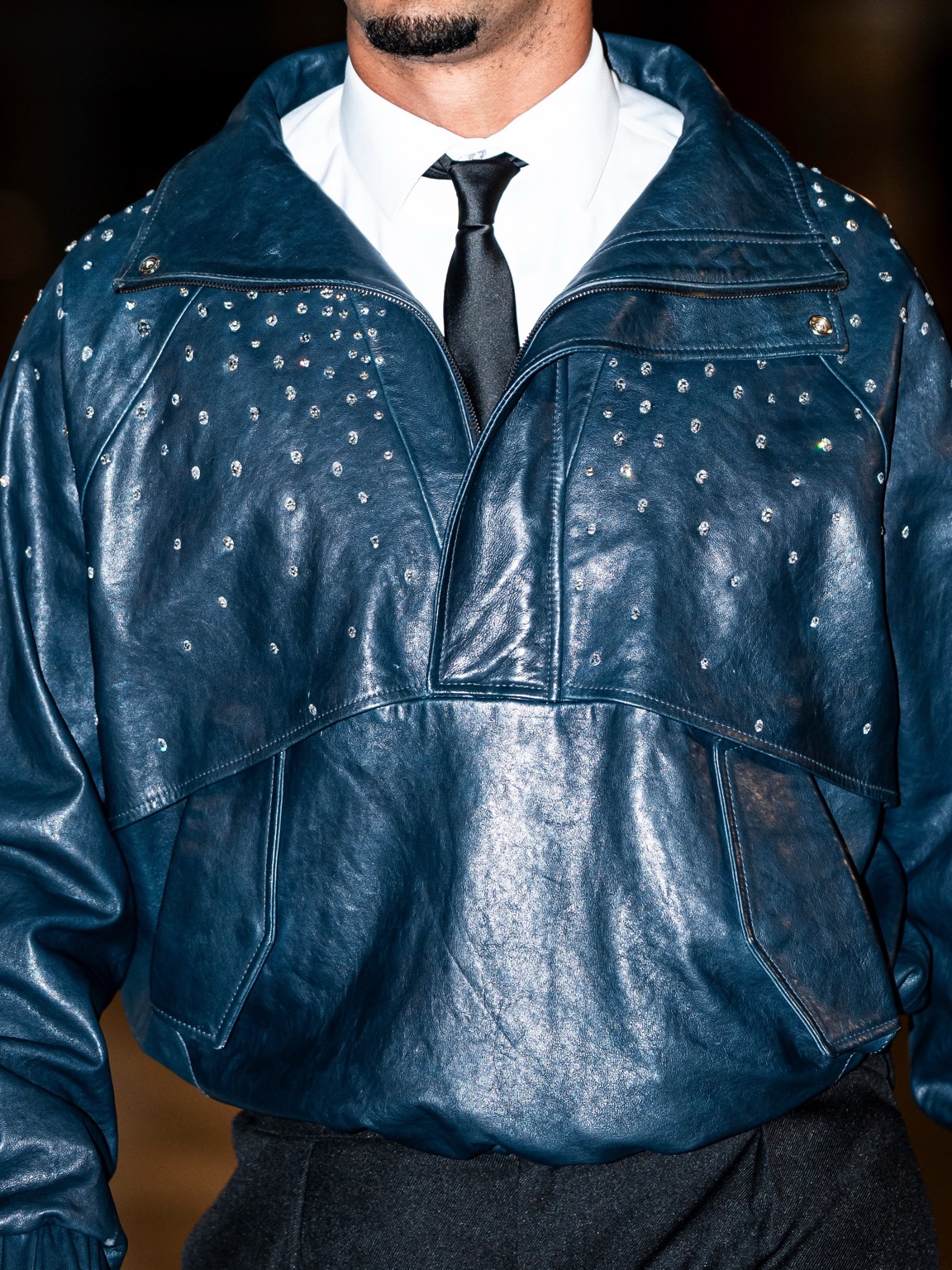 Close view of Jordan Love’s midnight blue leather jacket showing diamonds spaced across the chest and shoulder panels.