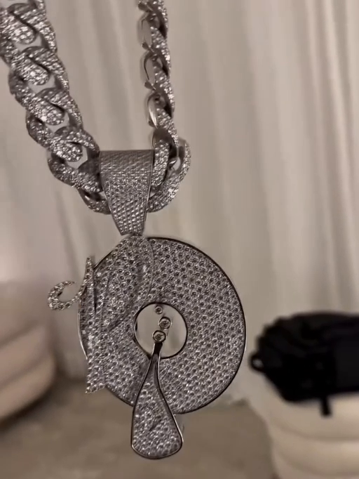 A Roc-A-Fella pendant suspended from a triangular bail and stone-set links, shown in a frame from a chain-only video.