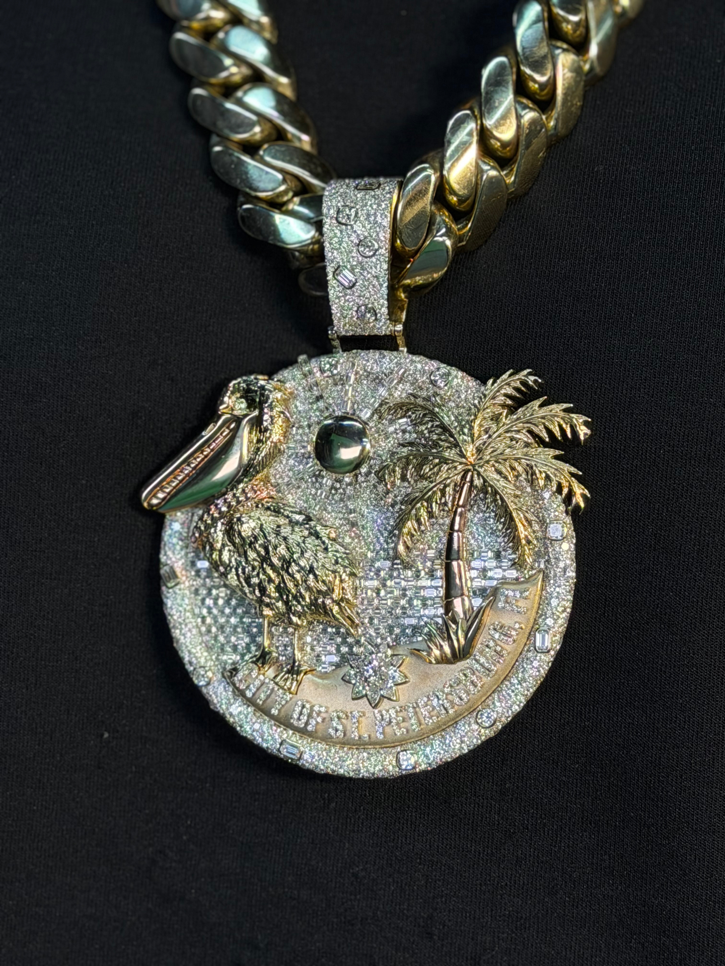 Angled view of the St. Pete seal pendant on a heavy gold Cuban link chain